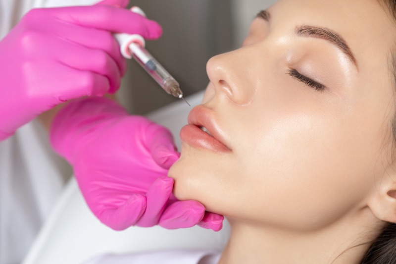 A girl doing this noninvasive treatment called lip fillers